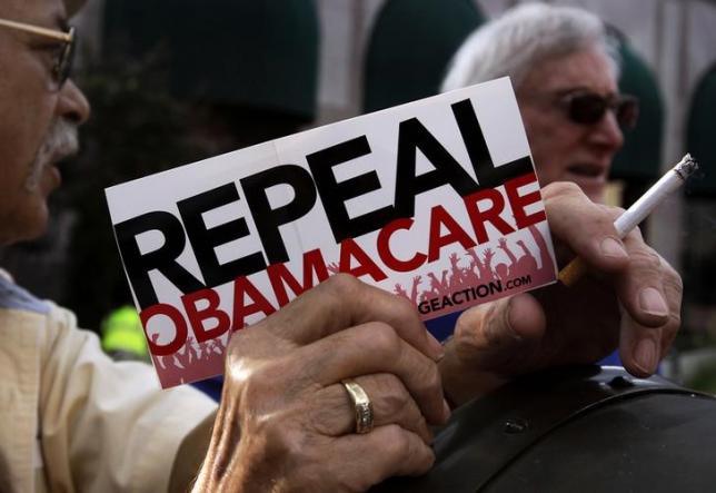 A small group of demonstrators stand outside of the HIlton Hotel and Suites prior to former South Carolina Senator Jim DeMint president of the The Heritage Foundation speaking at a'Defund Obamacare Tour rally in Indianapolis