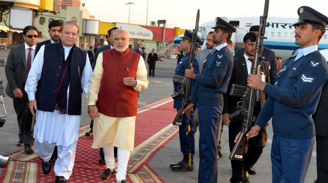 Pakistani Prime Minister Nawaz Sharif along with his Indian counterpart Narendra Modi walk through a guard of honour in Lahore