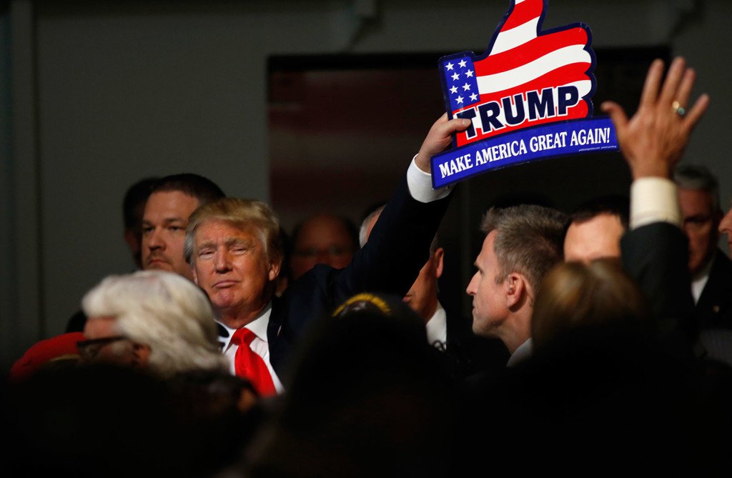 Republican presidential candidate Donald Trump holds one of his signs after a rally coinciding with Pearl Harbor Day at Patriots Point aboard the aircraft carrier USS Yorktown in Mt. Pleasant S.C. on Monday