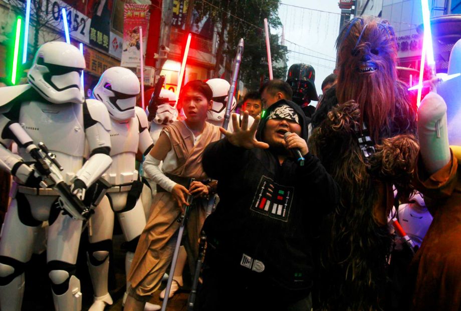 Fans dressed as Star Wars characters parade outside a movie theater showing'Star Wars The Force Awakens Saturday Dec. 19 2015 in Taipei Taiwan