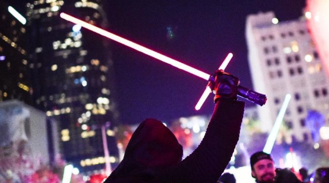 A Star Wars fan dressed as Kylo Ren raises his lightsaber during Lightsaber Battle LA in Pershing Square in downtown Los Angeles California