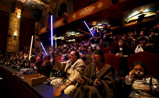 Moviegoers cheer and wave lightsabers before the first showing of the movie'Star Wars The Force Awakens at the TCL Chinese Theatre in Hollywood on Dec. 17