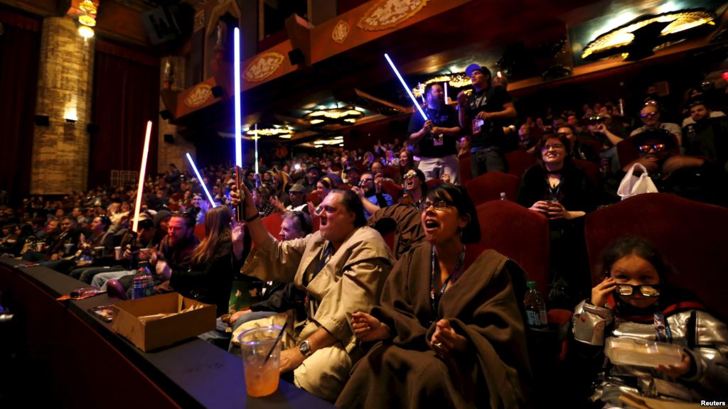 Moviegoers cheer and wave lightsabers before the first showing of the movie'Star Wars The Force Awakens at the TCL Chinese Theatre in Hollywood California Dec. 17 2015