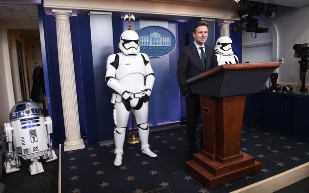 US Press Secretary Josh Earnest speaks to the press in the briefing room at the White House flanked by Star Wars characters R2D2 and Storm Troopers