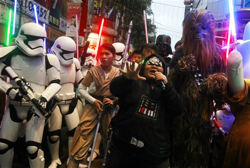 Fans dressed as Star Wars characters parade outside a movie theater showing'Star Wars The Force Awakens Saturday Dec. 19 2015 in Taipei Taiwan