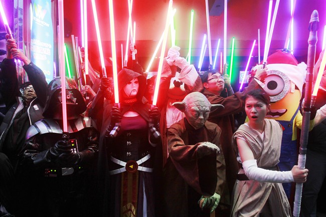 Fans dressed as Star Wars characters parade outside a movie theater showing