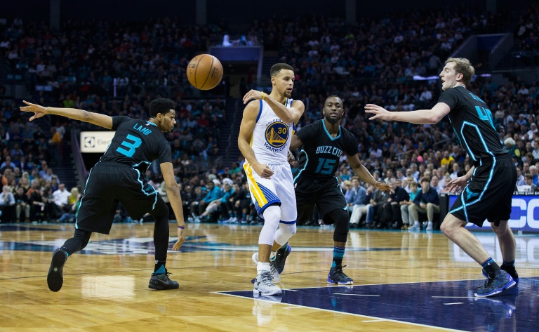 Getty Images  AFP  Brian A. Westerholt Stephen Curry of the Golden State Warriors makes a no look pass as he is defended by Jeremy Lamb, Kemba Walker and Cody Zeller of the Charlotte Hornets at Time Warner Cable Arena