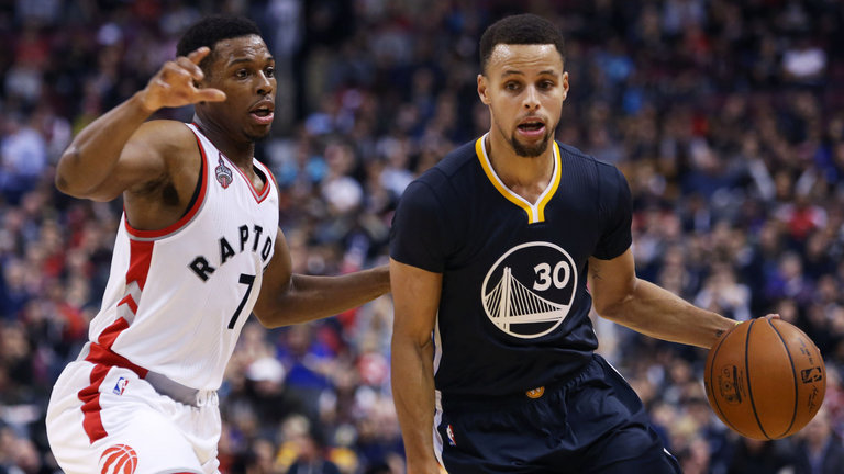 Stephen Curry of the Golden State Warriors dribbles around Kyle Lowry of the Toronto Raptors