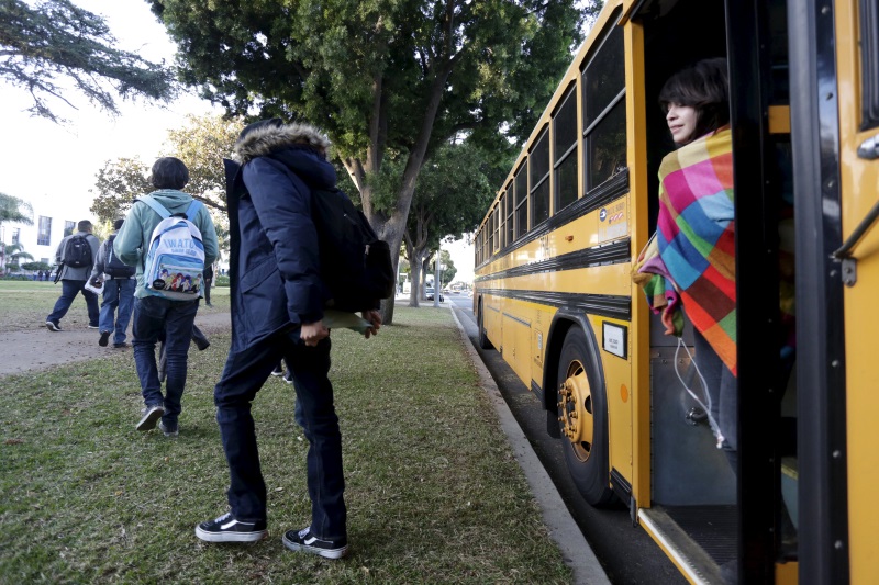 Students exit a bus as they arrive at Venice High School in Los Angeles California