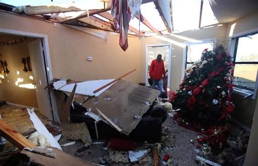 Ladarren Phillips surveys tornado damage to a house on Rising Star Road in Holly Springs Mississippi on Thursday. | Stan Carroll  The Commercial Appeal via AP