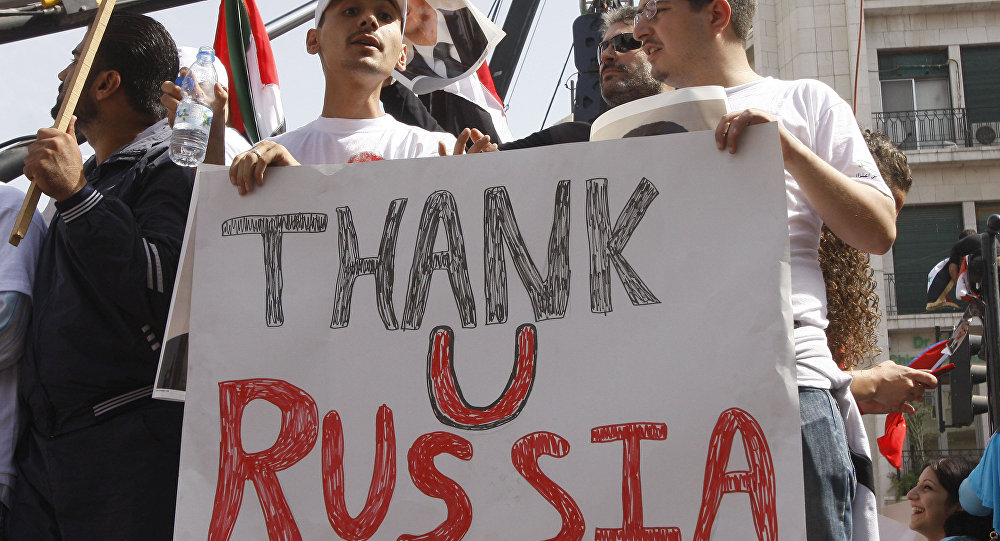 Supporters of the Syrian government hold a banner to show their support for Russia in Damascus Syria