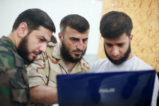 Zahran Alloush, commander of Jaysh al Islam looks at a screen during a conference in the town of Douma eastern Ghouta in Damascus Syria