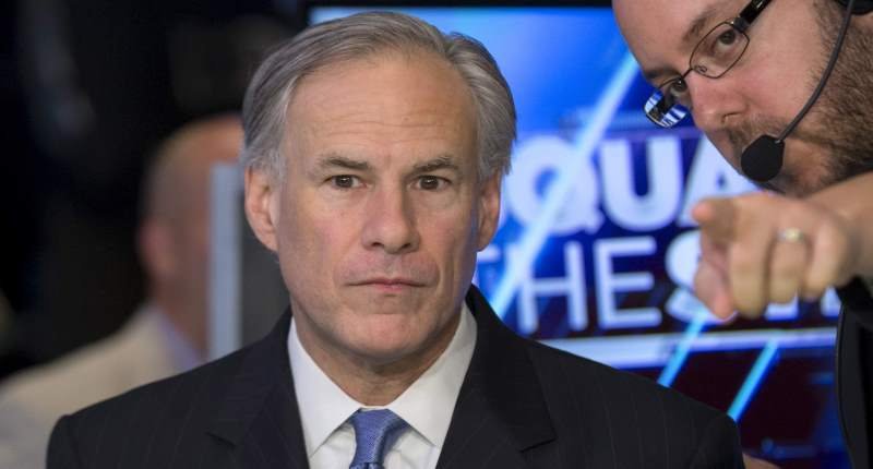 Texas governor Greg Abbott is given directions before an interview with CNBC on the floor of the New York Stock Exchange in this