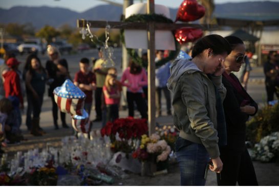 Bystanders pay respects at a makeshift memorial to honour the victims of Wednesday's shooting rampage on Saturday in San Bernardino Calif. Investigators have shifted their focus on the wife of the couple who committed the shooting