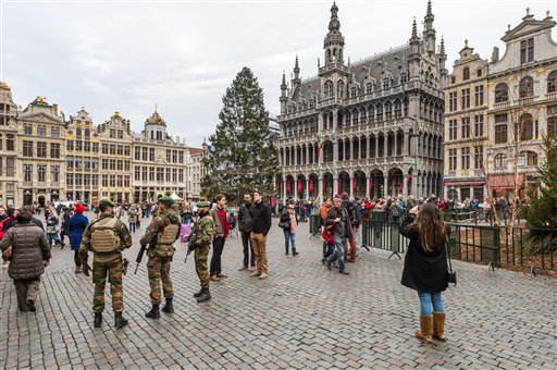 Belgian soldiers patrol as tourists visit the Grand Place in Brussels on Tuesday Dec. 29 2015. Two people have been arrested in Belgium on suspicion of planning attacks in Brussels during the holidays the federal prosecutor's office said Tuesday