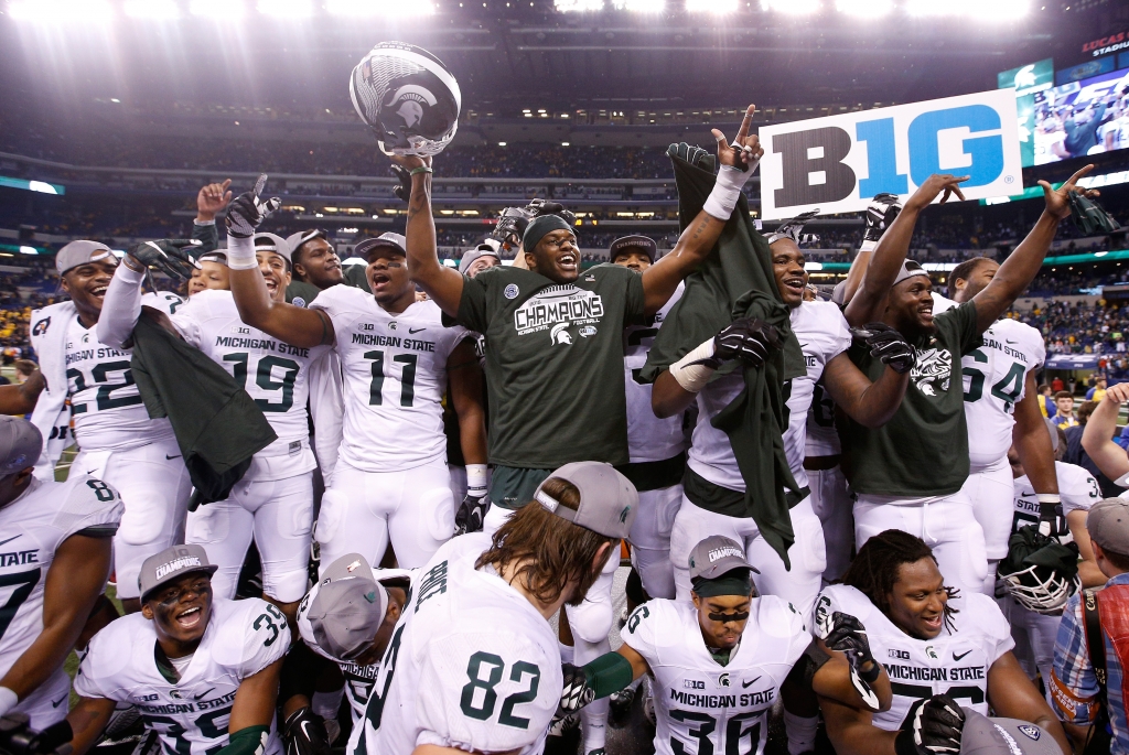 The Michigan State Spartans celebrate after winning the Big Ten championship against Iowa