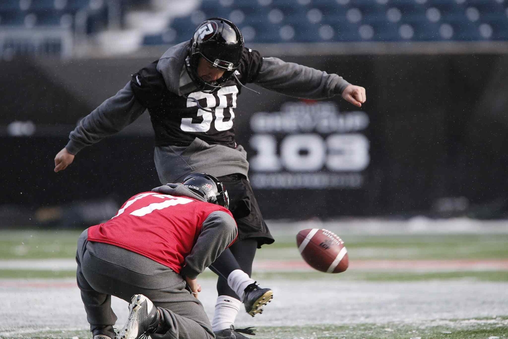 Ottawa Redblacks kicker Chris Milo kicks as quarterback Thomas De Marco holds during Grey Cup practice in Winnipeg Wednesday