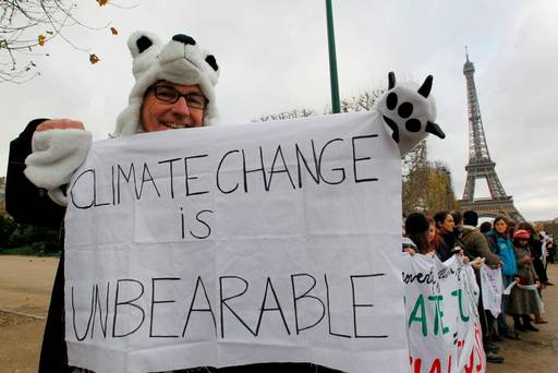 A man wears a polar bear costume and holds a banner with the message'Climage Change is Unbearable as he participates in a demonstration near the Eiffel Tower in Paris France REUTERS  Mal Langsdon