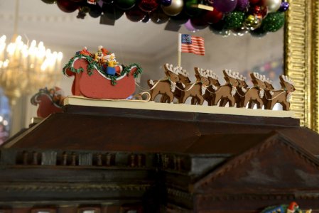 Santa Claus and his reindeer sit on the roof of the a White House created in brown chocolate decorated with a wreath toys Nutcracker dolls and trimmings in the State Dining Room of the White House a preview of Holiday decorations being assembled for