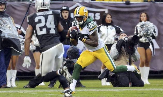 Green Bay Packers wide receiver James Jones catches a touchdown pass next to Oakland Raiders free safety Charles Woodson during the second half of an NFL football game Sunday Dec. 20 2015 in Oakland Calif