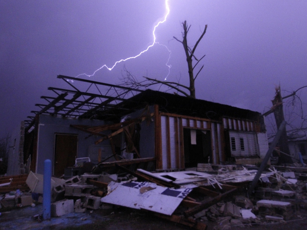 Lightning illuminates a house after a possible tornado touched down in Jefferson County Ala. damaging several houses on Friday in Birmingham Alabama