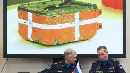 Russian generals talk as an image of the flight data recorder from the Russian warplane is displayed on a screen in the background