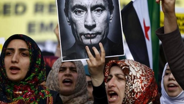 Demonstrators holding a defaced poster of Russia