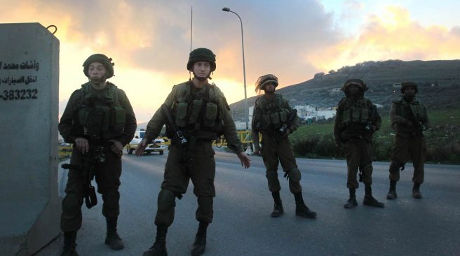 Israeli security forces stand guard at the site of a car ramming attack at the Huwara checkpoint near the West Bank city of Nablus