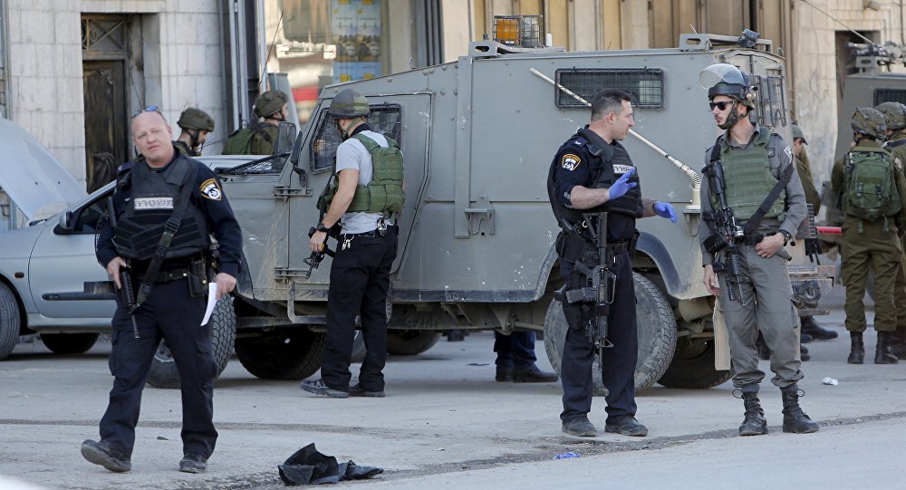 Israeli policemen stand guard near the scene where two Palestinians who the Israeli military said stabbed and wounded an Israeli soldier were shot dead by Israeli forces in the village of Hewara near the West Bank city of Nablus