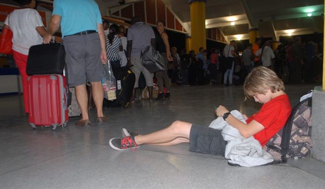 A child rests as passengers go through security screening at Moi International Airport Mombasa Kenya Sunday Dec. 20 2015 after their earlier flight was involved in a bomb scare and they were evacuated to different hotels in Mombasa