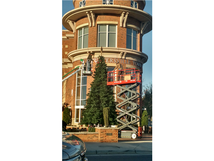 Two workers decorate downtown Huntersville for upcoming holiday events. Courtney Price Davis  Herald Weekly