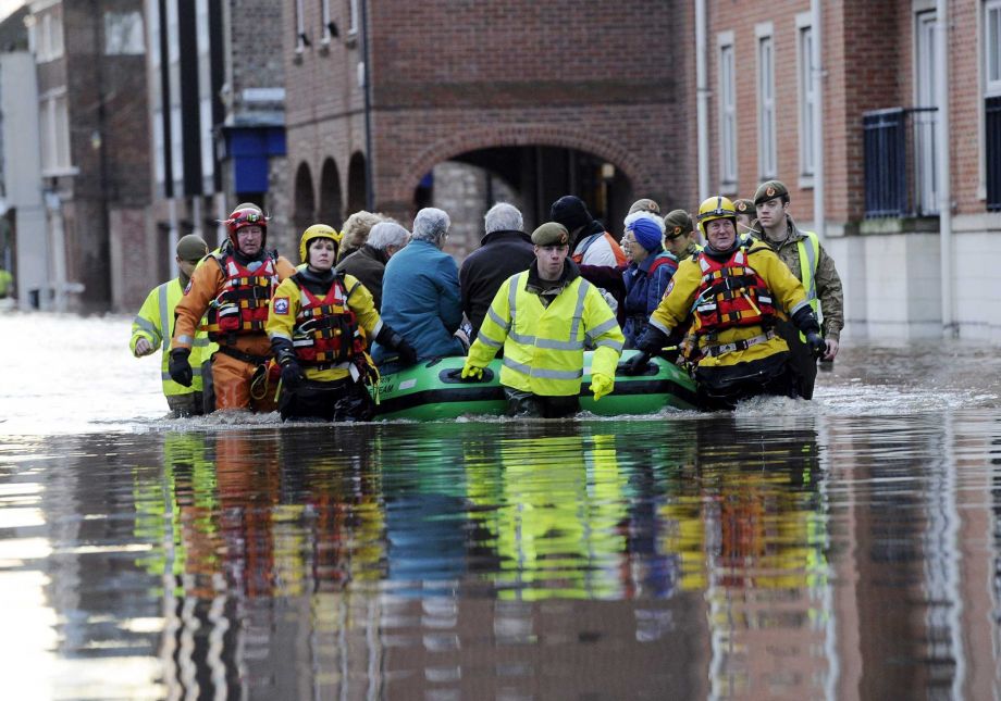 Members of the army and rescue teams help evacuate people from flooded properties after they became trapped by rising floodwater when the River Ouse bursts its banks in York city center Sunday Dec. 27 2015. Homes were evacuated cars were submerged and