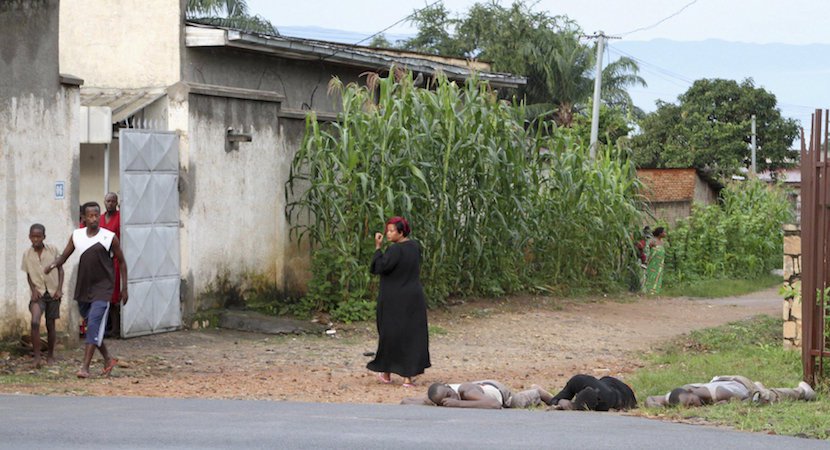 Residents look at the bodies of unidentified men killed during gunfire in the Nyakabiga neighbourhood of Burundi's capital Bujumbura