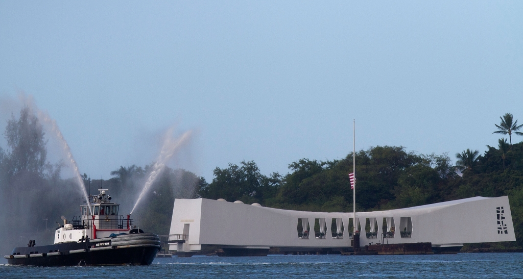 A tugboat fires water cannons near the Arizona Memorial during a memorial service for the 70th anniversary of the attack on the U.S. naval base at Pearl Harbor