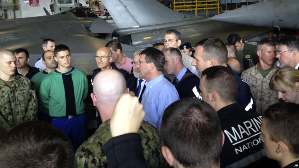 U.S. Secretary of Defense Ash Carter center in blue shirt speaks to U.S. and French troops on the French aircraft carrier Charles de Gaulle in the Persian Gulf Dec. 19 2015