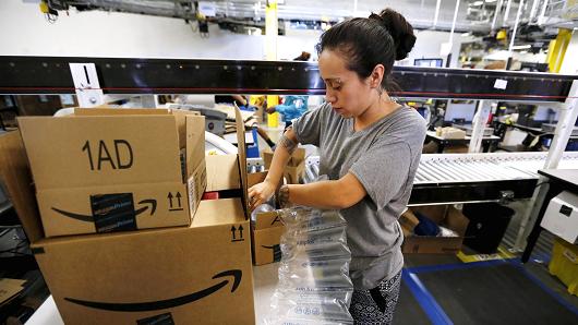 An employee secures customers&#039 orders with bubble wrap before they are shipped at the Amazon Fulfillment Center in Tracy California