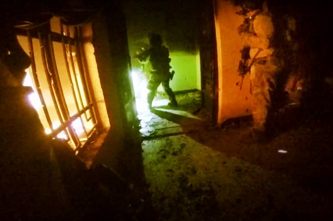 This image made from video taken on Thursday Oct. 22 2015 from a helmet camera shows U.S. and Iraqi special forces freeing hostages from a prison controlled by Islamic State militants in the town of Huwija 15 kilometers west of the Iraqi cit