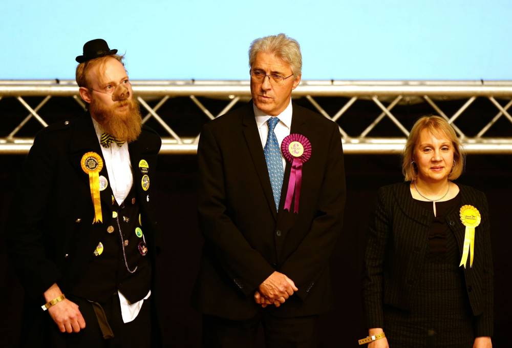 Ukip Candidate John Bickley listens to the declaration with Sir Oink Alot candidate for the Official Monster Raving Party and Lib Dem candidate Jane Brophy at the Oldham West and Royton constituency by-election count held at the C