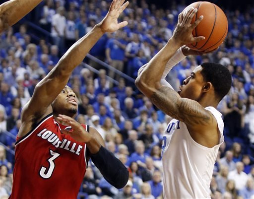 Kentucky's Tyler Ulis right shoots while defended by Louisville's Trey Lewis during the first half of an NCAA college basketball game Saturday Dec. 26 2015 in Lexington Ky