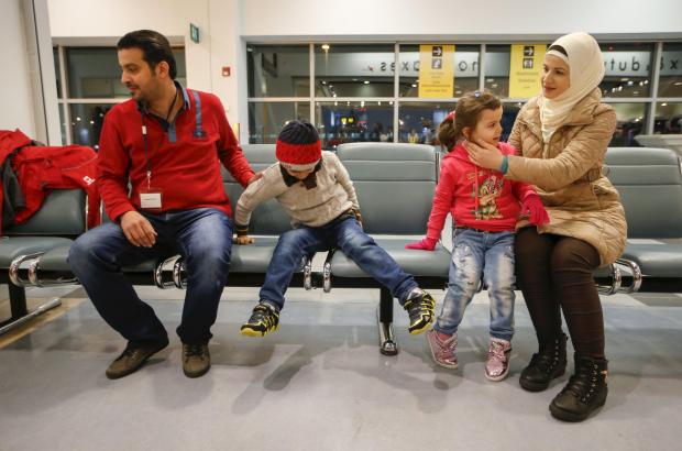 A Syrian refugee family sits down after arriving at the airport in Toronto