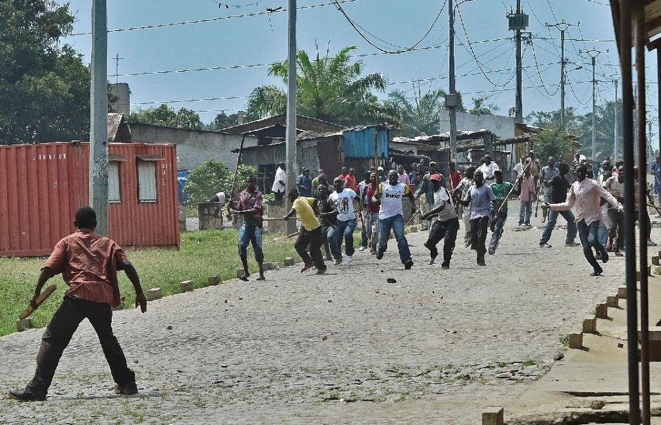 A protestor opposed to the Burundian president's third term confronts members of the Imbonerakure the youth wing of the ruling party in the Kinama neighborhood of Bujumbura