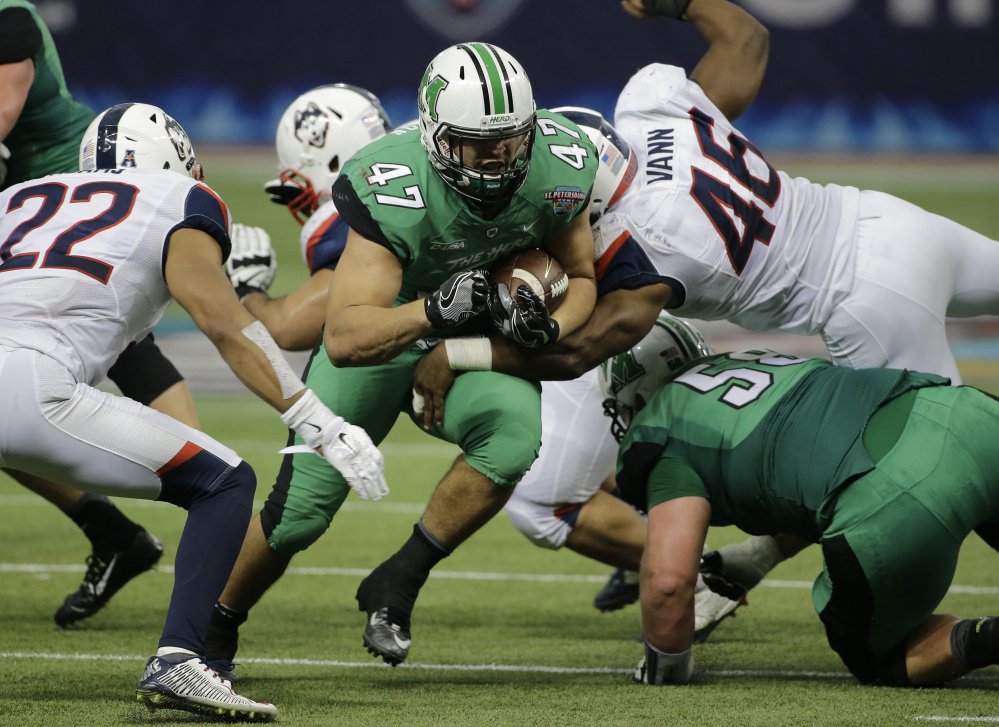 Devon Johnson of Marshall sprints through the Connecticut line during their St. Petersburg Bowl game in Florida. Marshall came away with a 16-10 victory and finished with a 10-3 record