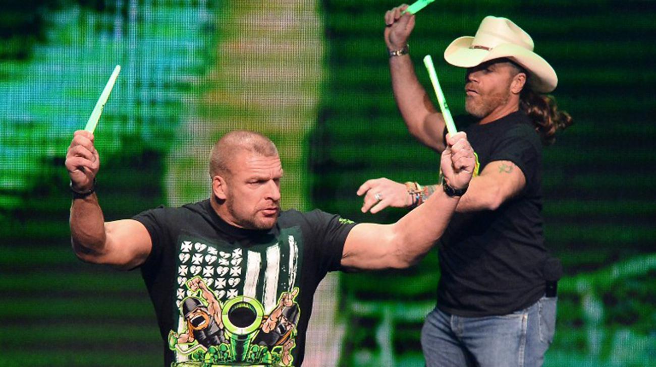 WWE personalities Triple H and Shawn Michaels throw glow sticks into the crowd at a news conference