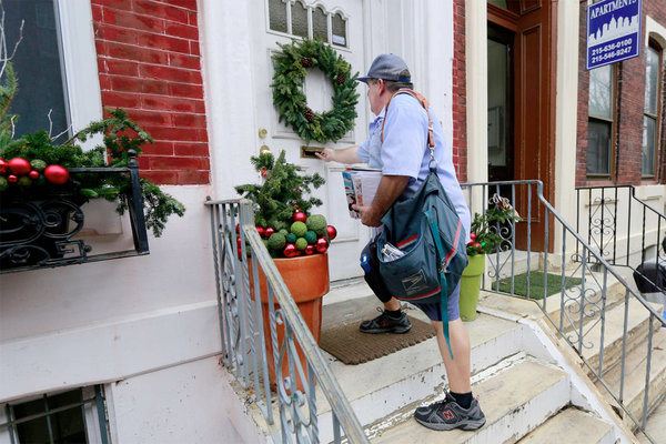 Vince Young dressed down as he delivered the mail on 26th Street near Parrish on Christmas Eve. Today temperatures could reach 70 degrees in Philadelphia