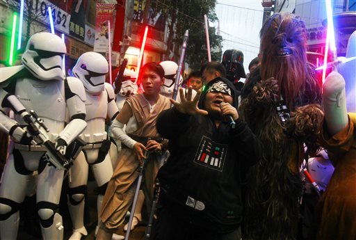 Fans dressed as Star Wars characters parade outside a movie theater showing