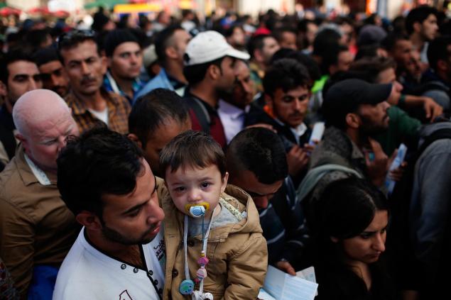 A young Syrian boy is held by his father as they try to cross a Hungarian police line for a train bound for Vienna Austria