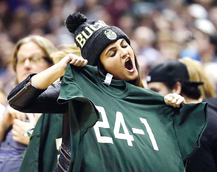 A Milwaukee Bucks fan holds a “24-1” shirt after her favorite team dealt the Golden State Warriors their first loss of the NBA season with a 108-95 victory