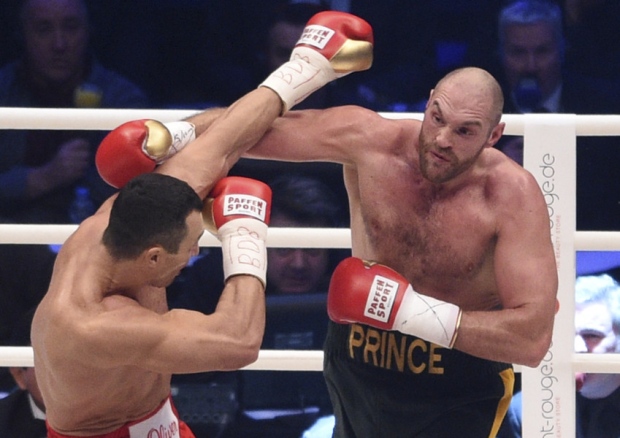 Ukraine's Wladimir Klitschko left and Britain's Tyson Fury exchange blows in a world heavyweight title fight for Klitschko's WBA IBF WBO and IBO belts in the Esprit Arena in Duesseldorf western Germany Saturday Nov. 28 2015. (AP