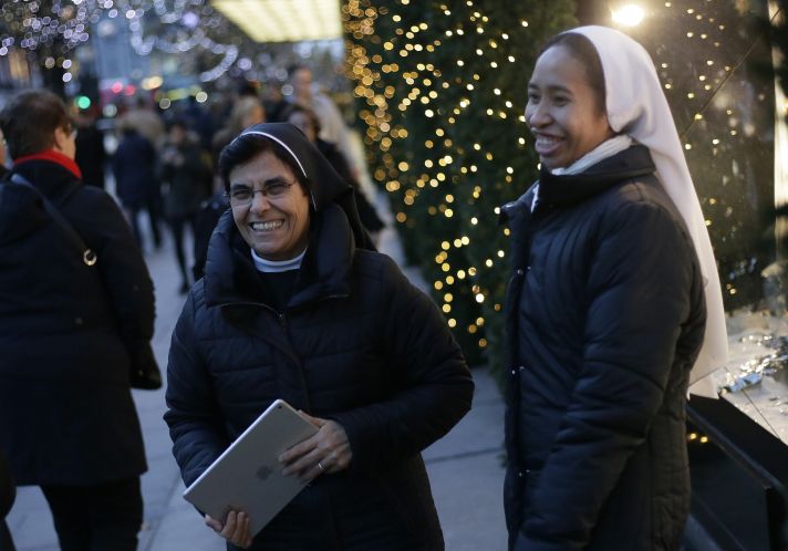 Women smile outside Selfridges department store on Oxford Street in London on Wednesday