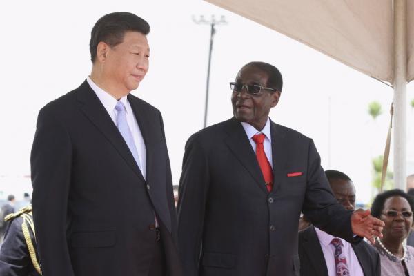 Chinese President Xi Jinping talks with Zimbabwean President Robert Mugabe on arrival for a state visit in Harare Zimbabwe